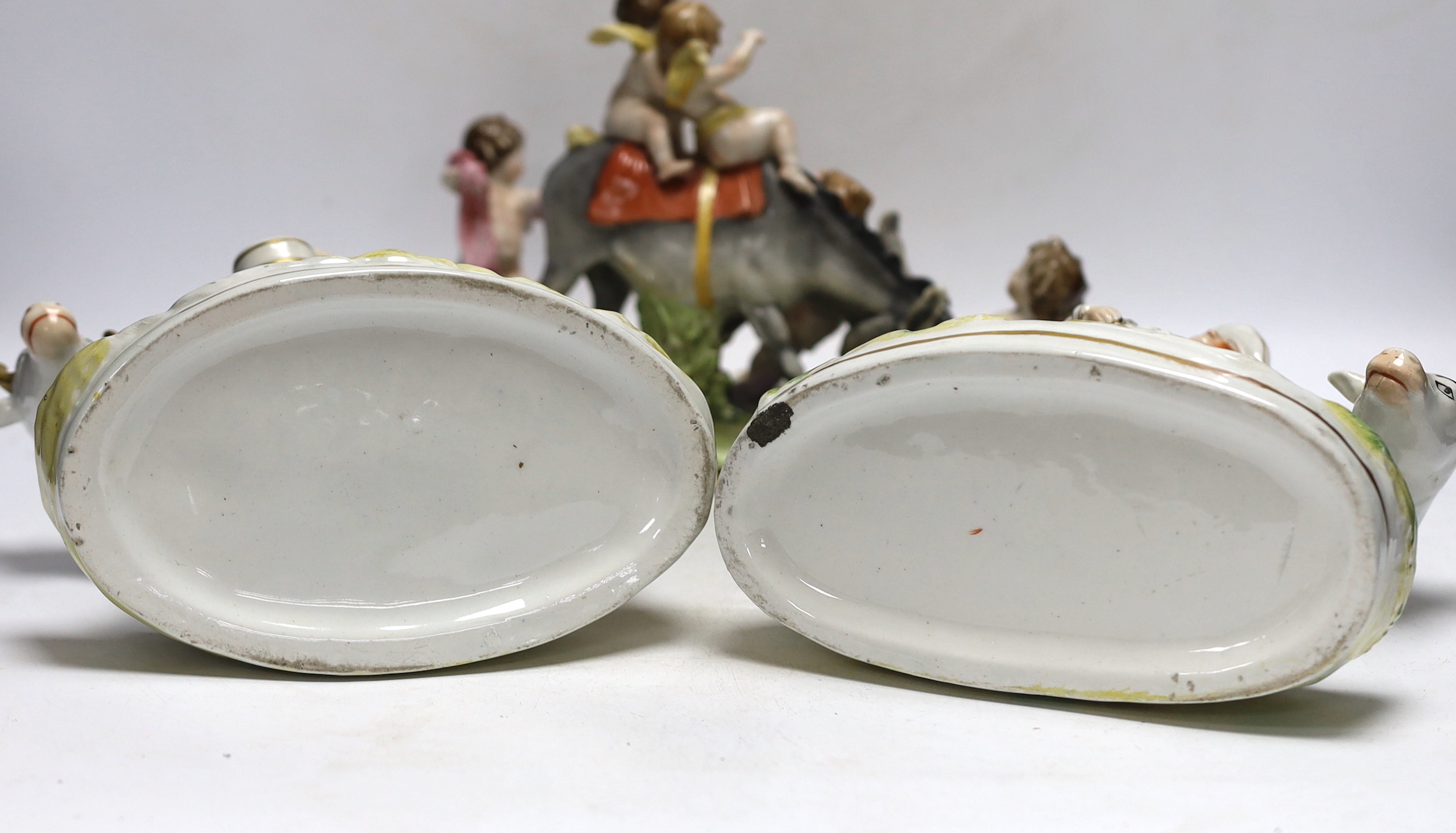 A pair of 19th century Staffordshire cow groups and an Italian donkey and cherub group, tallest 20.5cm